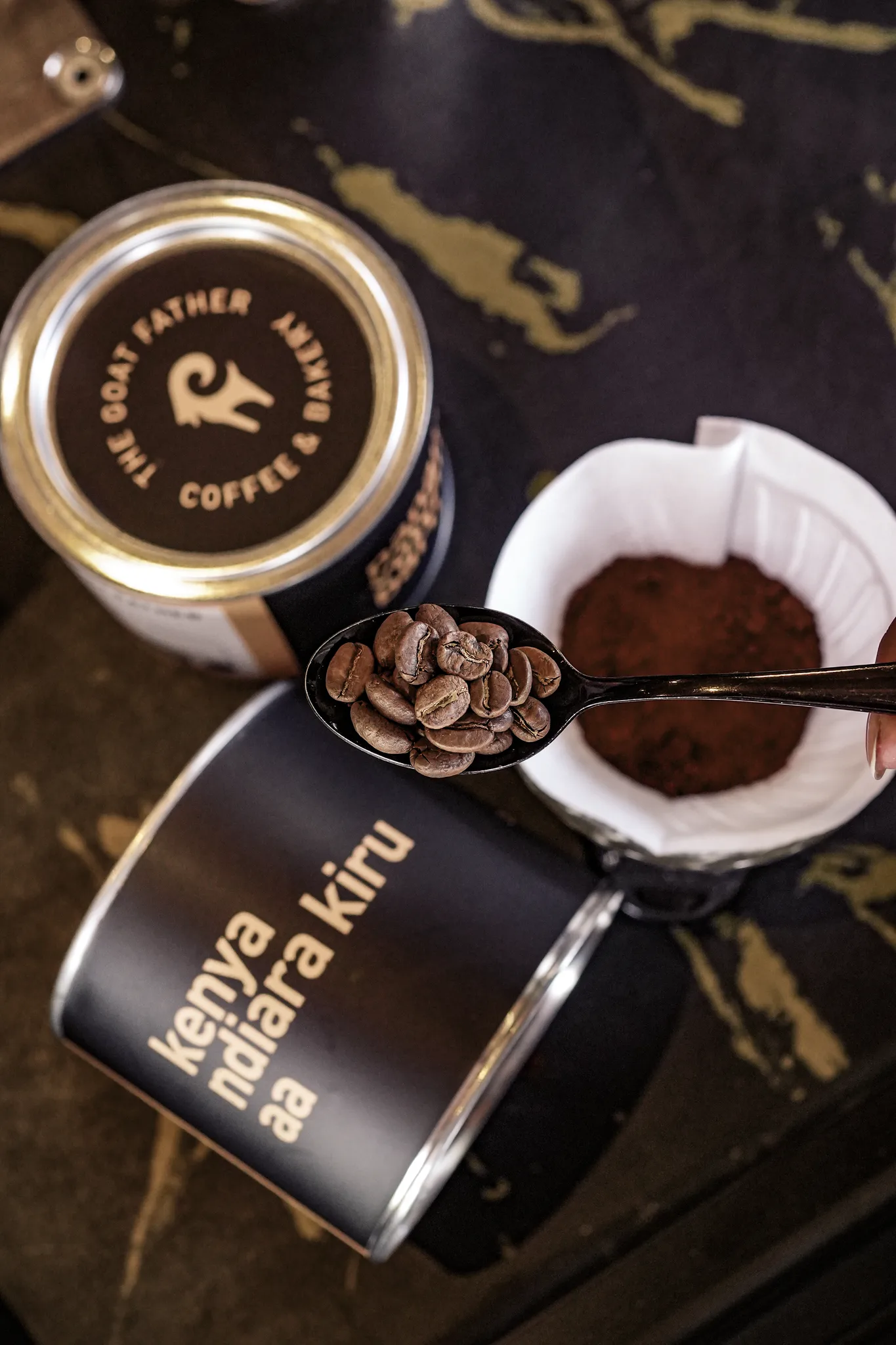 The Goat Father gold-branded coffee tin with fresh grounds